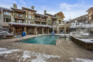 a hotel with a swimming pool in the snow at Mountainside Ski Lodge in Park City