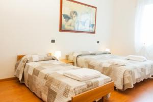 two beds in a room with a picture on the wall at Alloggio Cavour in Ferrara