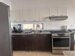 uma cozinha com um lavatório e um fogão forno superior em Villa Paradise Playa Del Carmen em Playa del Carmen
