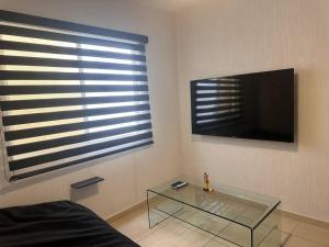 een woonkamer met een glazen tafel en een flatscreen-tv bij Villa Paradise Playa Del Carmen in Playa del Carmen