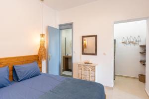 a bedroom with a blue bed and a mirror at Galazio Seaside Luxury Rooms & Coffee Shop in Platamonas