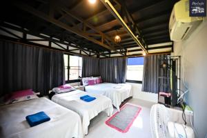 Zimmer mit 3 Betten und einem TV. in der Unterkunft มีจันทร์เขาค้อ in Ban Thung Samo