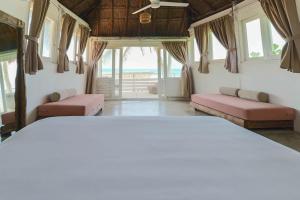 a bedroom with a bed and windows with a view of the ocean at Tuup Oceanfront in Tulum