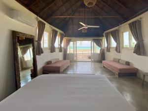 a large room with a bed and a ceiling fan at Tuup Oceanfront in Tulum