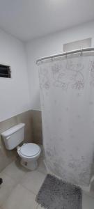 a bathroom with a white toilet in a room at A la sombra del calden in Santa Rosa