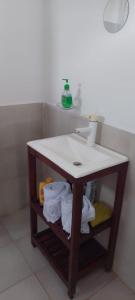 a bathroom with a sink and a shelf with towels at A la sombra del calden in Santa Rosa