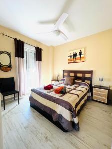 sypialnia z dużym łóżkiem i wentylatorem sufitowym w obiekcie El faro II Apartment con vista w mieście Huelva