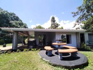 un patio con mesas de picnic frente a una casa en blanc haus, en Grecia