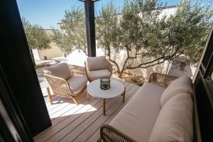 a patio with two chairs and a couch and a table at The Beach Eco Resort Premium Mobile Homes by OIKO Collection in Tisno