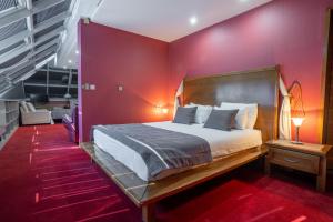 a bedroom with a bed and a red wall at Hotel Astra in Sarajevo