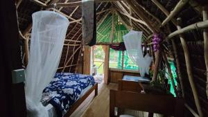 um quarto com uma cama e uma janela com cortinas em Serenity Treehouse em Port-Olry