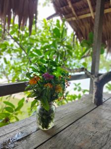 a glass jar filled with flowers sitting on a table at Serenity Treehouse in Port Olry