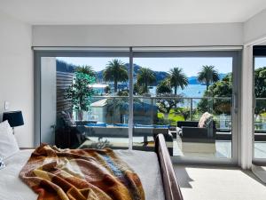 a bedroom with a bed and a view of the ocean at Picton Waterfront Apartments in Picton