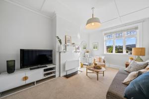 uma sala de estar com um sofá e uma televisão em Capital Charm - Wellington Holiday Unit em Wellington