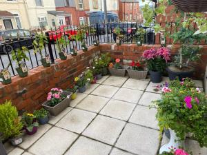 a garden with potted plants and flowers in pots at Grace's Home in Rotherham