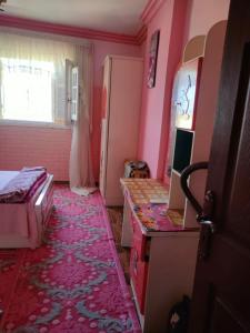 Habitación con paredes rosas y dormitorio con cama. en الاسكندريه الابراهيميه, en Alejandría