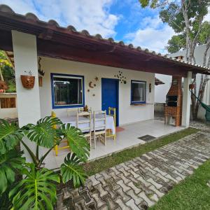a small white house with a table and chairs at Vila Axé Flat Lua in Prado