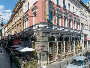 un edificio in una strada cittadina con tavoli e sedie di Hotel Astra a Sarajevo