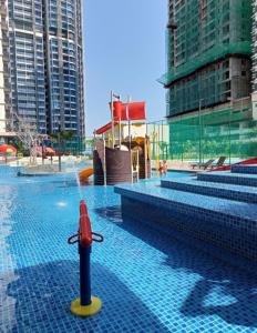 a swimming pool with a fire hydrant in the water at Bali Residence Melaka by Naufal in Melaka