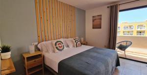 um quarto com uma cama e uma grande janela em Casa Cotillo 13 next to Los Lagos Beach Highspeed Wifi em Cotillo