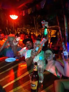grupa ludzi siedzących w barze i trzymających komórki w obiekcie Casa Shangri La w mieście Canoa