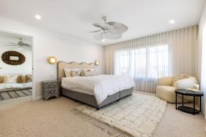 a white bedroom with a bed and a chair at Coastal Haven in North Creek