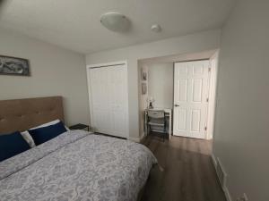 ein Schlafzimmer mit einem Bett und einem Schreibtisch. in der Unterkunft Cozy 2 Bedroom Suite, Queen Beds, Near the Airport in Edmonton