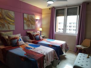 1 dormitorio con 2 camas y ventana en Las Palmeras, 893, en Fuengirola