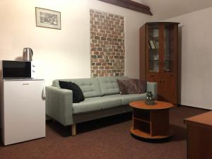 ein Wohnzimmer mit einem Sofa und einem Kühlschrank in der Unterkunft Apartman Reduta in Lučenec