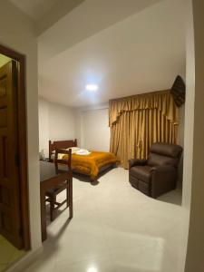 um quarto com uma cama, um sofá e uma cadeira em VILLA VICTORIA em Chachapoyas