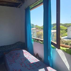 een slaapkamer met een bed en een raam met uitzicht bij Hostel Morgan in Piriápolis