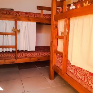 een kamer met 2 stapelbedden en witte gordijnen bij Hostel Morgan in Piriápolis