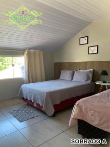 ein Schlafzimmer mit 2 Betten und ein Schild an der Wand in der Unterkunft Sobrados aconchegante com piscina "Natisashouse" in Bombinhas