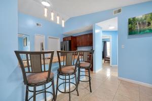 a kitchen with three bar stools in a room at Luxury Villa in Orlando 4BD/3BA - 14 min Disney in Orlando