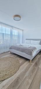 a white bedroom with a bed and a rug at The Beach House in Kent