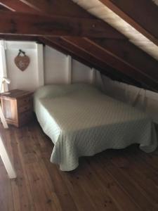 a small bedroom with a bed and a wooden floor at Bungalow Candy avec piscine in Rivière-Salée