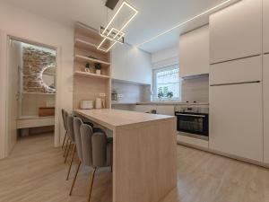 una cocina con una gran isla rodeada de sillas. en Apartments Mateo en Vodice