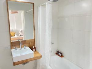 een badkamer met een wastafel, een bad en een spiegel bij Estilo Crespo in Buenos Aires