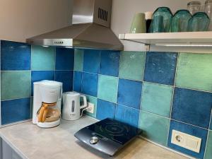 a kitchen with blue and green tiles on the counter at Old Center Apartment in Liepāja +17 photos