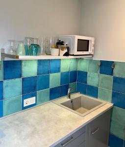 a kitchen with a sink and a microwave at Old Center Apartment in Liepāja