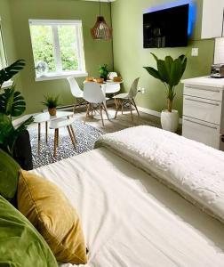 ein Schlafzimmer mit einem weißen Bett sowie einem Tisch und Stühlen in der Unterkunft Hidden Gem: Historical Gastown in Vancouver
