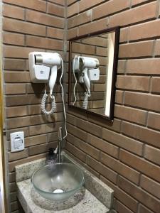 La salle de bains est pourvue d'un lavabo et d'un miroir. dans l'établissement Casa aconchegante, à Bragança Paulista