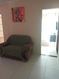 uma sala de estar com uma cadeira e um quadro na parede em Casa Aurora da Chapada em Mucugê