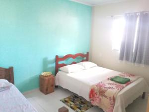 - une chambre avec 2 lits et un mur bleu dans l'établissement Casa Aurora da Chapada, à Mucugê