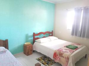 a bedroom with two beds and a blue wall at Casa Aurora da Chapada in Mucugê