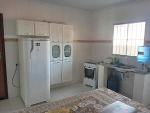 a kitchen with a white refrigerator and a stove at Casa Aurora da Chapada in Mucugê