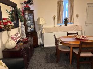 a living room with a table and a bed at Grace's Home in Rotherham