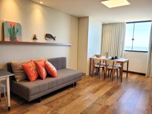 uma sala de estar com um sofá e uma mesa em Loft 320 - Residence Farol em Laguna