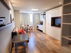 uma sala de estar com um sofá e uma mesa em Loft 320 - Residence Farol em Laguna