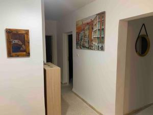 um corredor com dois quadros numa parede e um quadro em Appartement 5 lits climatisé salon 2chambres cuisine équipée SDB em Staoueli